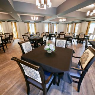 A spacious dining room with elegantly set tables and comfortable chairs.