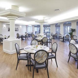 A modern dining area with empty tables and chairs, featuring elegant interior design.