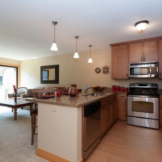 A modern kitchen with stainless steel appliances and an adjoining dining area.