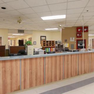 A spacious reception desk in an office setting with various office supplies and equipment.