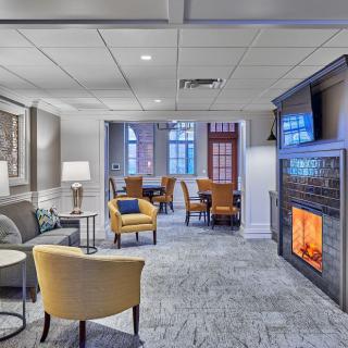 A cozy living room with modern decor, featuring a warm fireplace and comfortable seating.