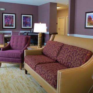 A cozy living room with a sofa and armchair set, complemented by framed artwork on the wall.
