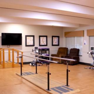 A rehabilitation room equipped with parallel bars for physical therapy exercises.