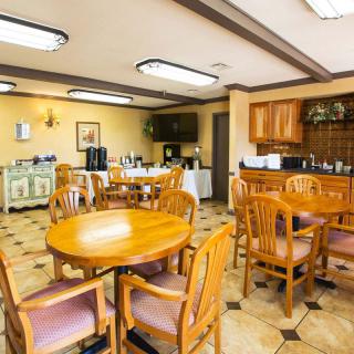 A cozy indoor dining area with wooden tables and chairs, featuring a coffee station.