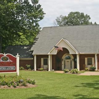 A quaint library building with a landscaped lawn and a welcoming entrance.
