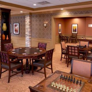 An inviting game room with a chess board and card tables ready for play.