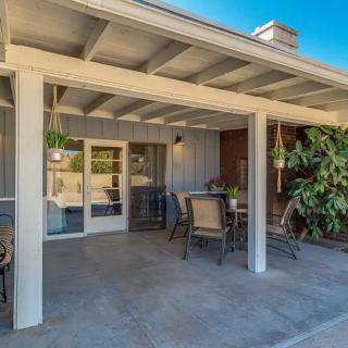A cozy outdoor patio with seating and a covered roof, perfect for relaxing.