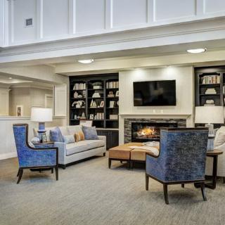 A cozy living room with a fireplace, bookshelves, and comfortable seating.