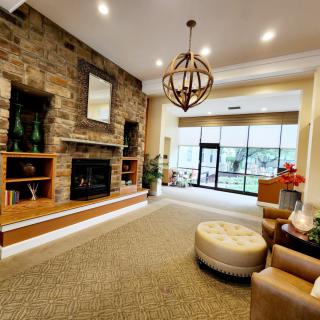 A modern lobby with a stone fireplace and seating area.