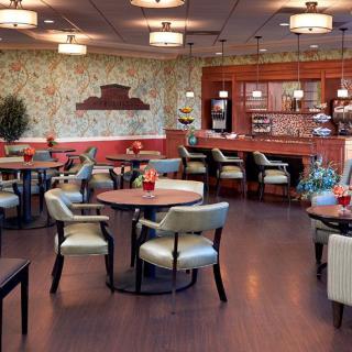 Cozy restaurant interior with a mix of tables, chairs, and a bar area.