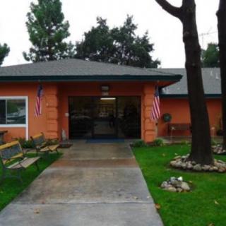 A building entrance with two American flags and a garden pathway.