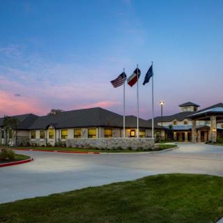 A building with flags at dusk under a colorful sky.