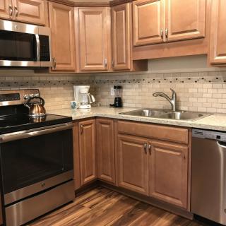 A modern kitchen with wooden cabinets and stainless steel appliances.