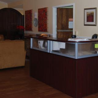 A welcoming reception area with a wooden counter and decorative artwork on the walls.