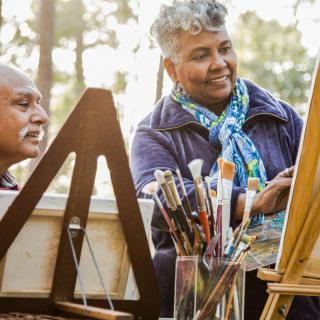 Two people enjoying painting together outdoors.