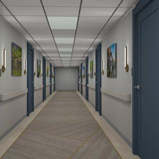 A well-lit hospital hallway with doors and framed pictures on the walls.