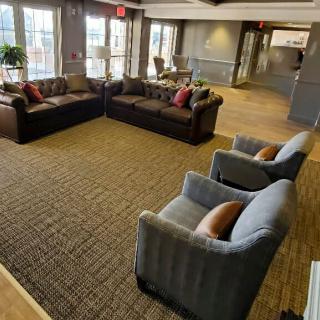 A cozy living room with sofas and chairs arranged on a carpeted floor.