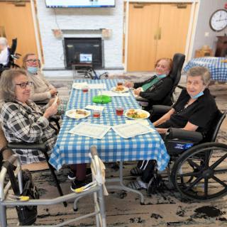 Seniors enjoying a meal together in a care facility.