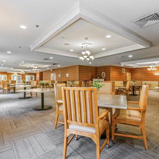 An interior view of a well-lit dining area with wooden tables and chairs.