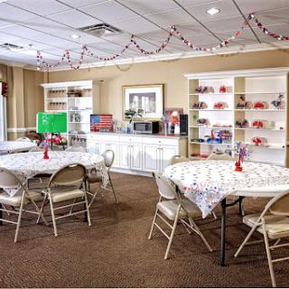 A welcoming community room equipped with tables, chairs, and shelves, perfect for gatherings and events.