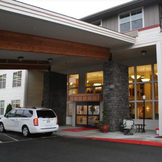 Entrance of a building with a parked van nearby.