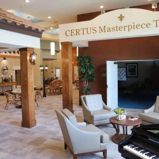 A beautifully designed lobby featuring a seating area, elegant decor, and a piano at the CERTUS Masterpiece Theater.