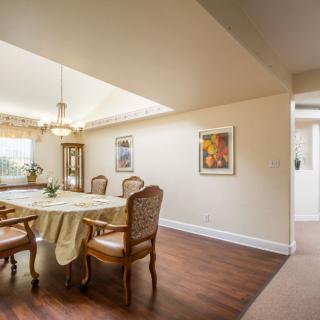 A well-lit dining room with elegant furniture and artwork on the walls.