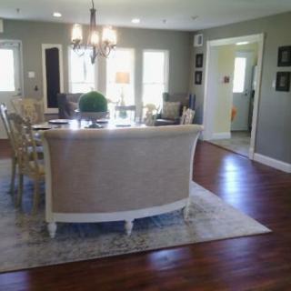 A modern living room with a dining area, featuring hardwood floors and elegant furnishings.