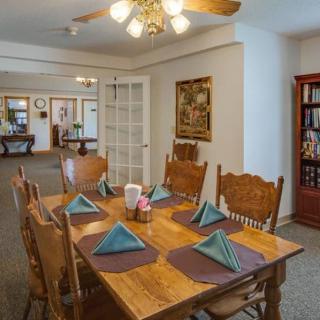 A cozy dining room with a wooden table set for a meal.