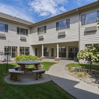 A serene courtyard with a picnic table and well-maintained garden surrounded by a residential building.