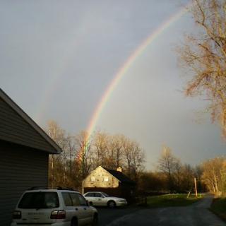 A beautiful rainbow arcs over a tranquil scene, highlighting the beauty of nature.