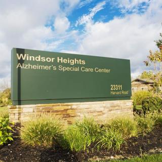 A sign for Windsor Heights Alzheimer's Special Care Center set against a landscaped background.