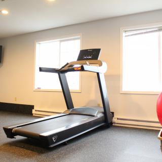 A treadmill in a well-lit gym room.