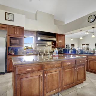 A spacious modern kitchen with wooden cabinets and a large island.