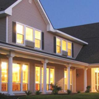 A beautiful two-story house with glowing lights during the evening.