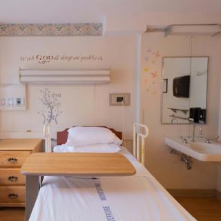 A bright and welcoming hospital patient room equipped with essential furniture and a clean environment.
