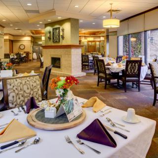 A beautifully set dining room with elegant decor and floral centerpiece.