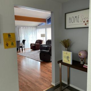 View from a hallway into a cozy living room with wooden floors and comfortable seating.