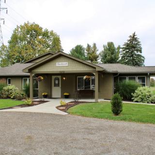 A single-story residential home with a landscaped garden and driveway.