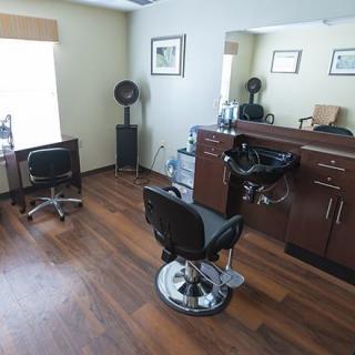 A modern hair salon interior with stylish chairs and mirrors.