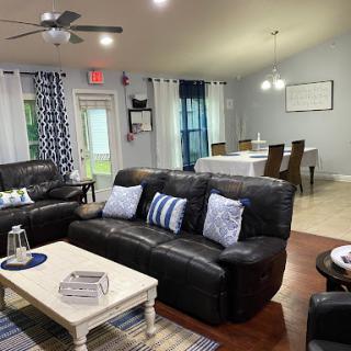 A cozy living room featuring comfortable leather sofas, a stylish coffee table, and a dining area with a modern aesthetic.