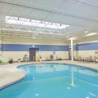 A spacious indoor swimming pool with seating area.
