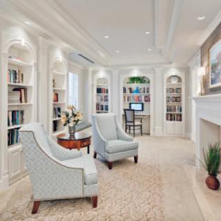 A beautifully designed home library with elegant armchairs, built-in bookshelves, and a cozy reading nook.