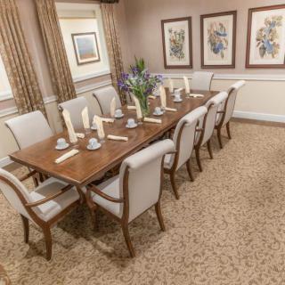 A formal dining room with a set table and elegant decor.