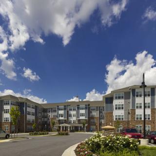 A modern residential building under a partly cloudy sky.