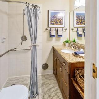 A modern bathroom with a shower and wooden vanity.