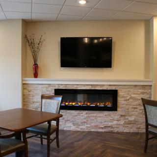 A cozy lounge area featuring a modern fireplace and television.