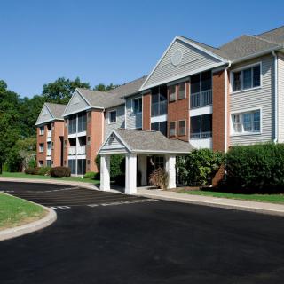 A modern apartment building with a brick exterior and well-maintained landscaping.