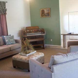 Cozy and inviting living room featuring comfortable seating and a vintage organ.