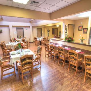 A spacious dining area with wooden furniture and warm lighting.